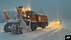 FILE - A Dec. 31, 2022, photo released by Caltrans District 3, California Department of Transportation shows crews clearing the road on Highway 50 over Echo Summit for avalanche control work in South Lake Tahoe, California. 
