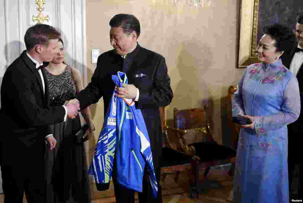 中國主席習近平和夫人在芬蘭赫爾辛基參加國宴前,接受芬蘭國家滑雪隊贈送的運動衣(2017年4月5日)。習近平夫婦從芬蘭來到美國。有評論人士認為,這是要顯示習近平並非專程訪美,而是順道訪美。