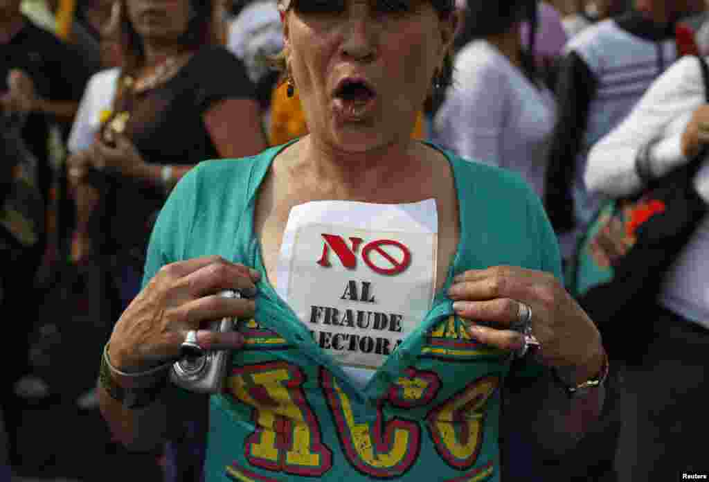 A supporter of opposition leader Henrique Capriles wears a sign that reads, "No election fraud," while demonstrating for a recount of the votes in Sunday's election, in Caracas, April 15, 2013. 