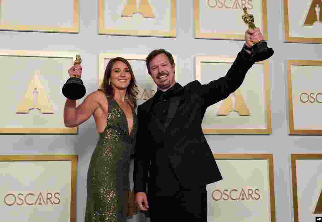 Pippa Ehrlich, left, and James Reed pose in the press room with the award for best documentary feature for "My Octopus Teacher" at the Oscars on Sunday, April 25, 2021, at Union Station in Los Angeles. (AP Photo/Chris Pizzello, Pool)