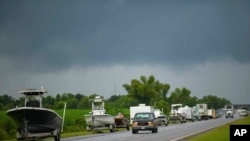 Boti, Malori na magari mengine yakiongozana katika barabara kuu ya Louisiana no 46 baada ya wamiliki wa vifaa hivyo kuvileta katika eneo ambalo liko salama wakati kimbunga Ida kikipiga katika mji wa St. Bernard Parish, Louisiana, Agosti. 28, 2021. 