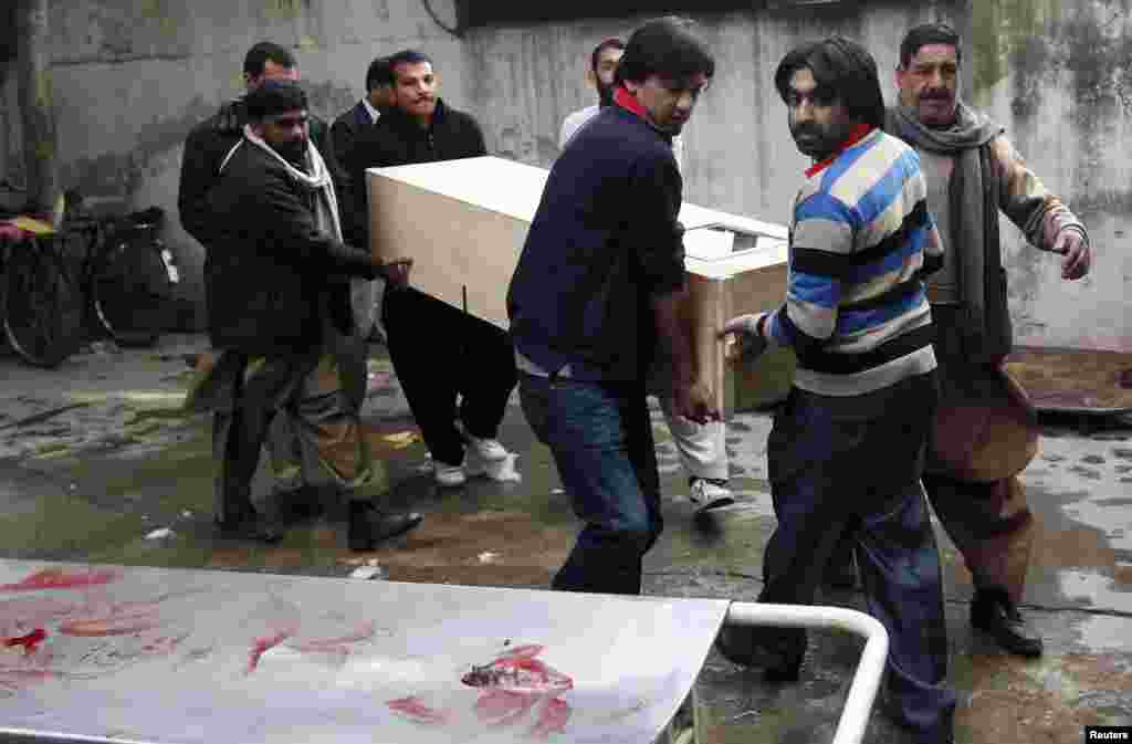 Relatives carry the casket of a victim who was killed in a bomb attack, at a hospital morgue in Rawalpindi, Pakistan, Jan. 20, 2014.