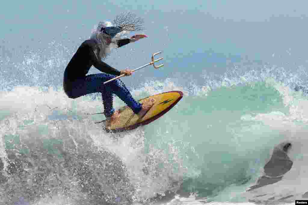 An entrant to the Kommetjie festival's Fancy Dress Surf Competition, going by the title King Neptune, competes in Cape Town, South Africa, Nov. 16, 2024.