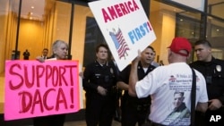 FILE - A supporter of President Donald Trump challenges police officers and a Deferred Action for Childhood Arrivals (DACA) program advocate during a rally in Los Angeles, California, Jan. 3, 2018. 