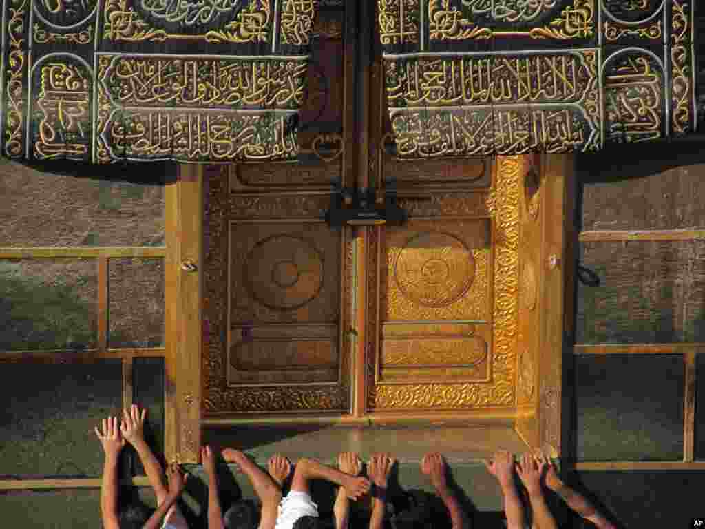 Muslim pilgrims pray at the door of the Kabaa, the cube-shaped structure in the city’s Grand Mosque that Muslims around the world face in prayer five times a day in the Muslim holy city of Mecca, Saudi Arabia, Oct. 13, 2013.