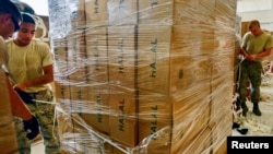 U.S. airmen from the 8th Expeditionary Air Mobility Squadron prepare boxes of halal meals for a humanitarian drop over Iraq in August 2014. A 2016 budget increase in foreign aid includes more support for humanitarian assistance.