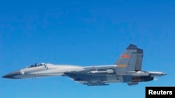 Jet tempur SU-27 China terming di atas Laut China Selatan. Foto diambil pads 24 Mei 2014 dan disebarkan oleh Kementerian Pertahanan Jepang, 25 Mei 2014. 