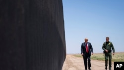 FILE - United State Border Patrol chief Rodney Scott gives President Donald Trump a tour of a section of the border wall in San Luis, Ariz.