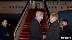 Menteri Luar Negeri AS John Kerry, kiri, disambut oleh Duta Besar AS untuk China Max Baucus setibanya di Beijing, 26 Januari 2016.