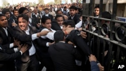A lawyer (c) who spoke to the media supporting student leader Kanhaiya Kumar, is beaten up by other lawyers outside a Delhi court, in New Delhi, India, Feb. 17, 2016.