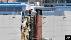 俄羅斯調查人員正在檢查據報被無人機毀壞的一個展覽館。（2023年8月18日）