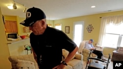 Un anciano descansa en su silla favorita mientras que el empleado que lo cuida, Warren Manchess, sale de la habitación.