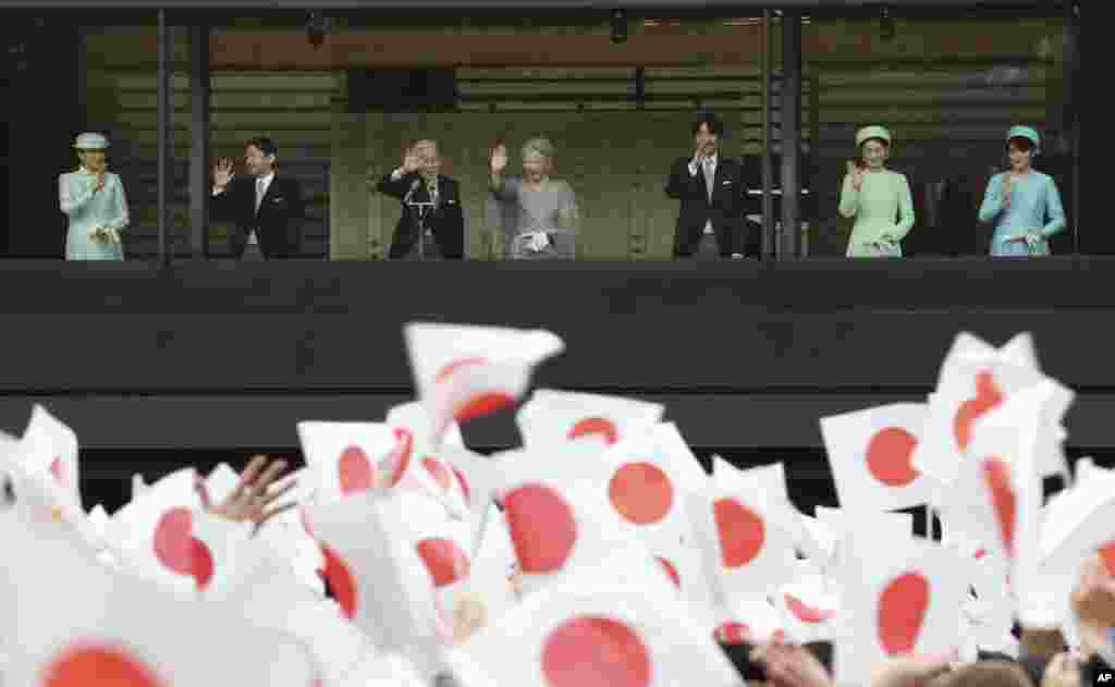 Japan's Emperor Akihito, accompanied by his wife Empress Michiko, and their family members, wave at well-wishers as they appear on the balcony of the Imperial Palace in Tokyo, Japan, Dec. 23, 2013.