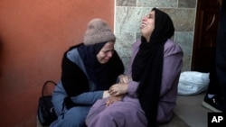 Palestinas lloran a sus familiares muertos en el bombardeo israelí de la Franja de Gaza frente a una morgue en Khan Younis el jueves 4 de enero de 2024.