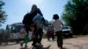 Sebuah keluarga migran asal Venezuela bergerak untuk menaiki kendaraan patroli perbatasan setelah mereka dan sejumlah migran lainnya menyeberang perbatasan AS-Meksiko dan menyerahkan diri kepada pihak berwenang di Del Rio, Texas, pada 16 Juni 2021. (Foto: AP/Eric Gay)