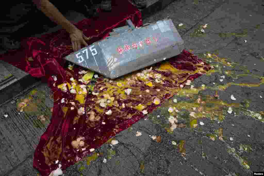 Demonstran anti-Vietnam melemparkan telur ke kapal-kapalan yang diletakkan di atas bendera Vietnam dalam sebuah demo membela klaim teritorial China dan mengutuk demo anti-China yang dilakukan oleh Vietnam, di Hong Kong, 19 Mei 2014. 
