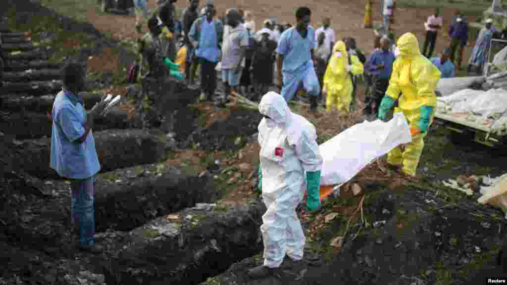 Le personnel de santé emporte le corps d’une victime d’Ebola qui va être enterré à Freetown, 17 décembre 2014. REUTERS / Baz Ratner