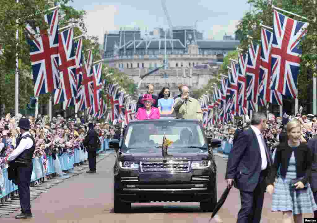 Britain's Queen Elizabeth and Prince Philip, and Princes William, Harry and Kate Duchess of Cambridge behind travel down the Mall waving guests during the Patron's Lunch, an event to mark her 90th birthday in London.