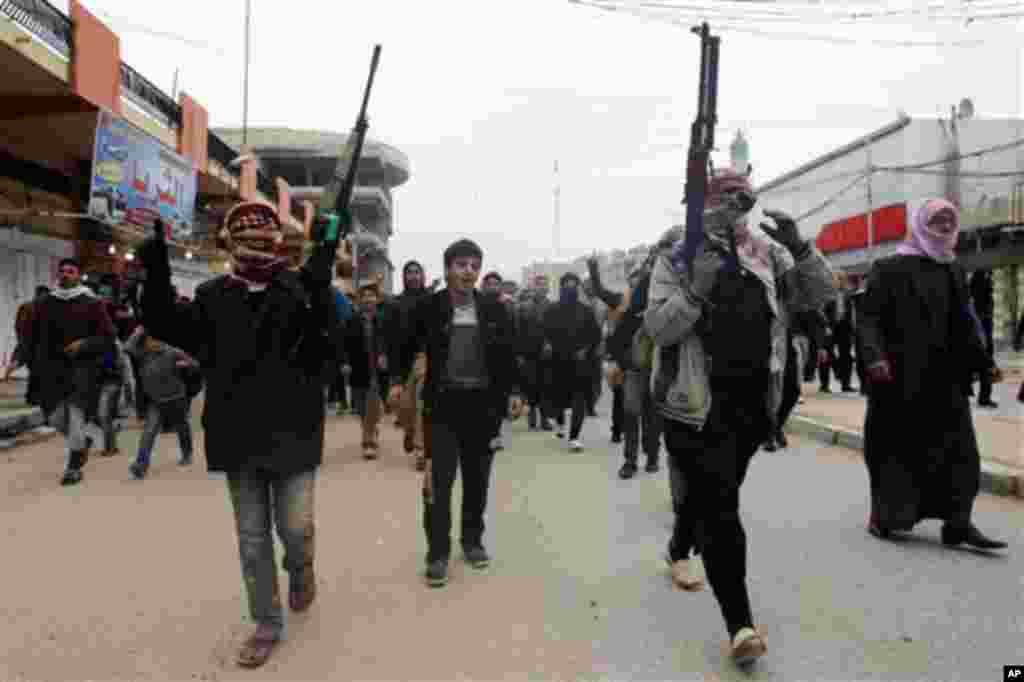 Mourners and Sunni gunmen chant slogans against Iraq's Shiite-led government during funeral of a man killed in clashes in Fallujah, Jan. 4, 2014.