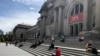 Des gens sont assis devant le Metropolitan Museum of Art le samedi 2 mai 2020 à New York, en respectant la distanciation sociale afin de prévenir la propagation du coronavirus. (Photo AP / Ron Blum)