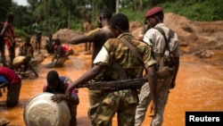 D'anciens soldats de la Selaka surveillent des prospecteurs d'or près de la mine à ciel ouvert de la mine de Ndassima enla République centrafricaine, le 9 mai 2014.