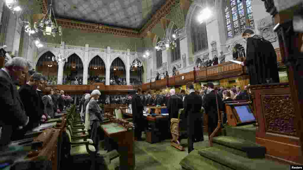 Canada's Members of Parliament stand in the chamber of the House of Commons in Ottawa, Oct. 23, 2014.