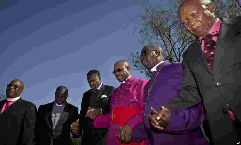 Uskup Abraham Sibiya, ketiga dari kanan, dan para perwakilan dari gereja-gereja berdoa untuk kesembuhan mantan Presiden Afrika Selatan Nelson Mandela di rumah sakit jantung dimana dia dirawat di Pretoria, Afrika Selatan.