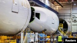 ARCHIVO - Un empleado pasa junto a una sección de fuselaje en construcción en el campus 787 Dreamliner de Boeing Co. en North Charleston, Carolina del Sur, EE. UU., 30 de mayo de 2023.