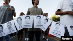 People hold photographs of missing students during a march in their support in Guadalajara Oct. 8, 2014.