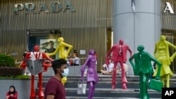 Orang-orang mengenakan masker saat berjalan di area perbelanjaan Orchard Road di Singapura pada 28 November 2021. (Foto: AP/Annabelle Liang)