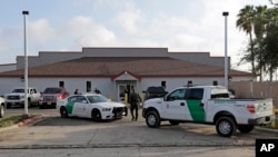FILE - A U.S. Border Patrol Agent walks between vehicles outside the Central Processing Center in McAllen, Texas, June 23, 2018. 