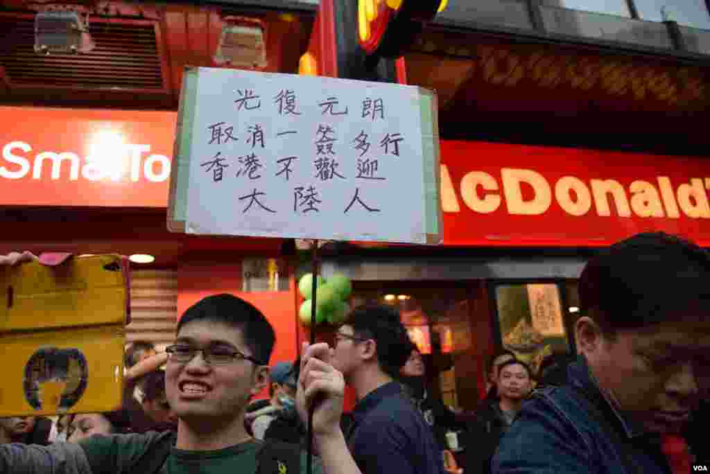 '光復元朗“反水貨示威人士舉牌要求取消一簽多行。(美國之音湯惠芸攝)