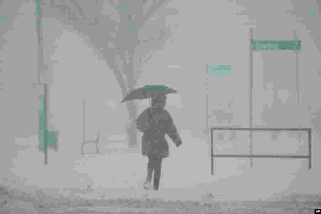 A person holds an umbrella as they walk during a winter storm, Jan. 6, 2025, in Cincinnati, Ohio.