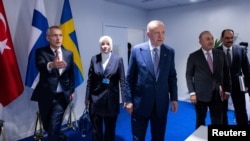 ARCHIVES - Le secrétaire général de l'OTAN, M. Jens Stoltenberg (à g.), et le président turc, M. Tayyip Erdogan (centre), lors d'une réunion trilatérale entre la Turquie, la Finlande et la Suède au sommet de l'OTAN à Madrid (Espagne), le 28 juin 2022. 