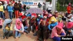 Workers gather during their strike in front of a factory owned by Sabrina (Cambodia) Garment Manufacturing in Kampong Speu province, west of the capital, Phnom Penh, May 30, 2013. 