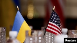 Bendera Ukraina dan Amerika Serikat tersemat di atas meja dalam pertemuan antara pejabat pertahanan kedua negara di Pentagon, Washington, pada 30 Agustus 2024. (Foto: Reuters/Daniel Becerril)