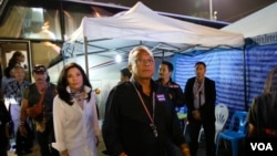 Pemimpin demonstrasi anti-pemerintah Suthep Thaugsuban (depan) bersama istrinya Srisakul Promphan (berbaju putih) tiba di monumen Demokrasi di Bangkok, Thailand (15/12). (AP/Manish Swarup)