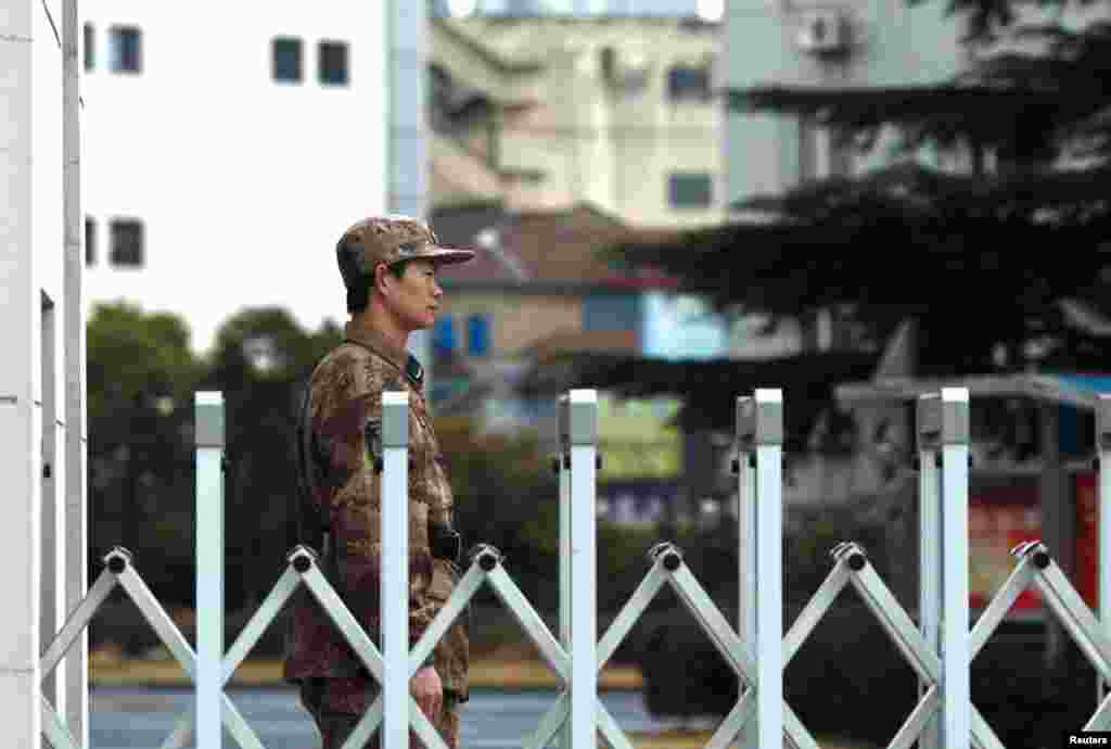 一名中国人民解放军士兵在上海的61398部队驻地门口站岗。曼迪昂特公司报告说,中国黑客的重点是从外国公司窃取技术图纸、制造流程等信息。