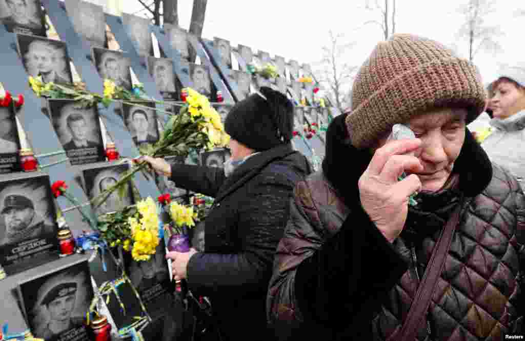 People attend a commemoration ceremony at a monument to the so-called "Heavenly Hundred", the anti-government protesters killed during the Ukrainian pro-European Union (EU) mass demonstrations in 2014, to mark the fifth anniversary of the start of the uprising in Kyiv, Ukraine.