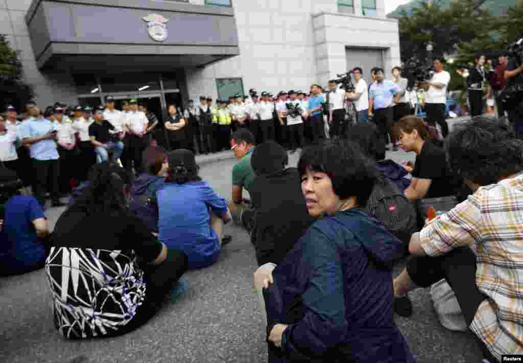 Para anggota keluarga korban tenggelamnya kapal feri Sewol di depan sebuah bangunan tempat awak kapal ditahan, usai menghadiri sidang pengadilan Gwangju, Korea Selatan (10/6).