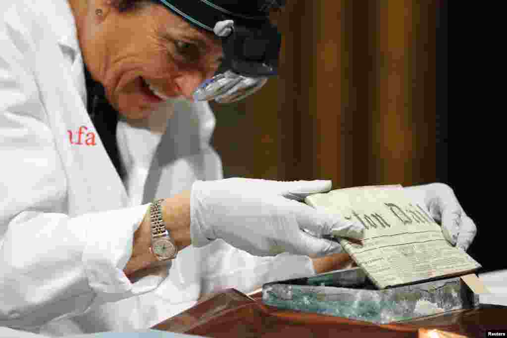Conservator Pam Hatchfield removes a newspaper from a time capsule, which was placed under a cornerstone of the State House in 1795, at the Museum of Fine Arts, Boston, Massachusetts, Jan. 6, 2015. The capsule was placed by a group of the U.S. founding fathers including Samuel Adams, then the state's governor, and patriot Paul Revere.