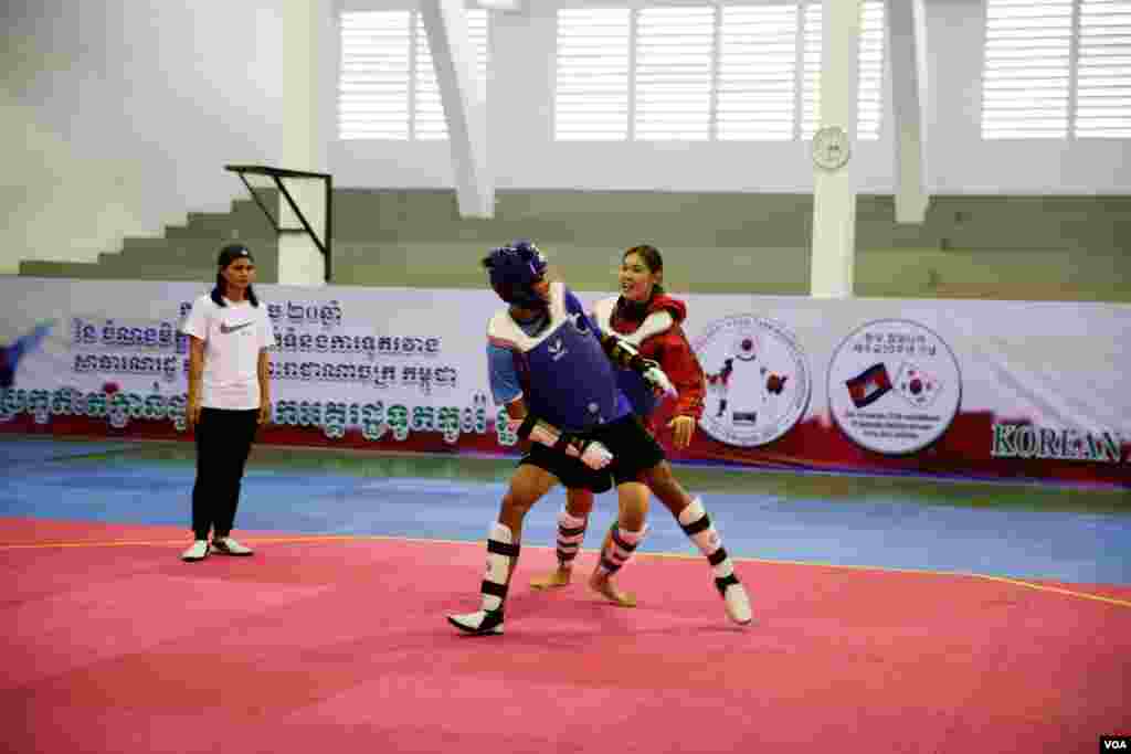 កីឡាករតៃក្វាន់ដូ កំពុងហ្វឹកហាត់ ជាមួយគ្រូបង្វឹកខ្លួន សម្រាប់ការប្រកួតកីឡាស៊ីហ្គេម នាពេលខាងមុខ ឯស្តាតអូឡាំពិចក ក្នុងរាជធានីភ្នំពេញ នៅថ្ងៃទី៤ ខែសីហា ឆ្នាំ២០១៧។ ក្រុមកីឡាករកម្ពុជា នឹងចូលរួមប្រកួតកីឡាស៊ីហ្គេមលើកទី ២៩ នាទីក្រុងគូឡាឡាំពួ ប្រទេសម៉ាឡេស៊ី នាពាក់កណ្តាលខែសីហានេះ។ (រិទ្ធី គីមហេង/ VOA)