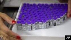 Un agent de santé tient un plateau avec des flacons de vaccin Pfizer pour COVID-19 lors d'un programme de vaccination prioritaire dans un centre médical communautaire à Sao Paulo, Brésil, le 6 mai 2021.