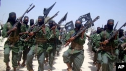Al-Shabab fighters march with their weapons during military exercises on the outskirts of Mogadishu, Somalia. 