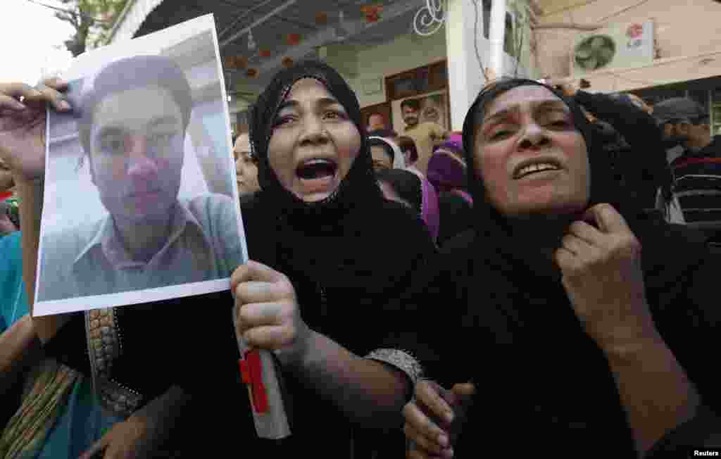 A relative of Arslan and a supporter of the Muttahida Quami Movement (MQM) political party who was detained by paramilitary forces during a raid on MQM's headquarters, protests in Karachi, March 11, 2015.