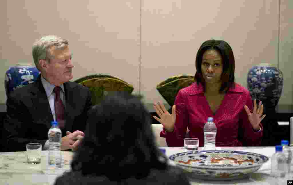U.S. first lady Michelle Obama speaks next to U.S. Ambassador to China Max Baucus as they attend a round table discussion on education at the U.S. Embassy in Beijing, March 23, 2014.