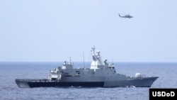 3月12日美国海军直升机与马来西亚海军配合搜寻失踪的马航370班机（图片由美国海军提供）