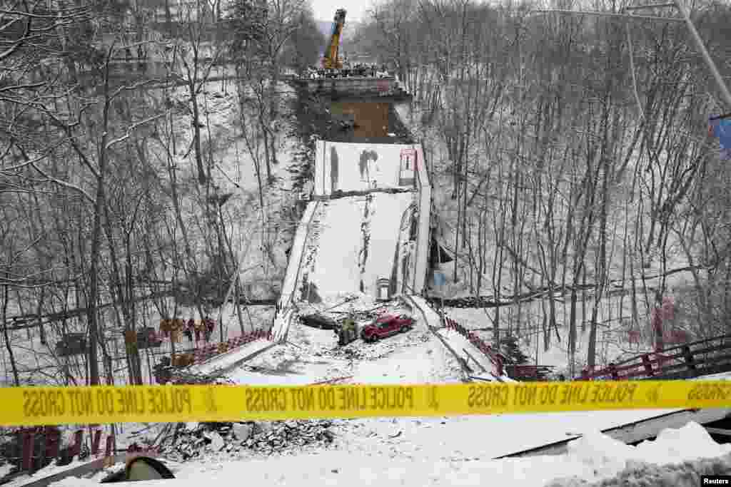 Vehicles are seen on the remains of a bridge that collapsed prior to a visit by U.S. President Joe Biden in Pittsburgh, Pennsylvania.