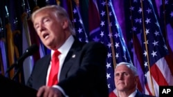 President-elect Donald Trump speaks as Vice president-elect Mike Pence watches during an election night rally in New York, Nov. 9, 2016.