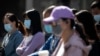 Orang-orang yang memakai masker di tengah kekhawatiran virus corona, di sebuah jalan di Beijing pada 13 Mei 2020. (Foto: AFP/Noel Celis)